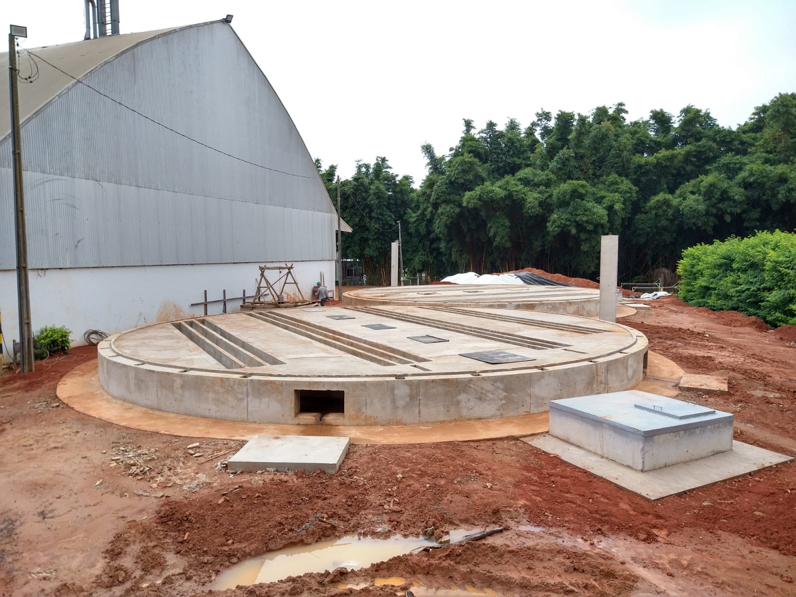 Bases circulares de silos concluídas ao lado de armazém graneleiro